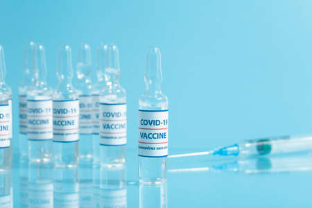 Vaccine against COVID-19. Glass medical vials with liquid. Ampoules with coronavirus vaccine on a medical glass tableの写真素材