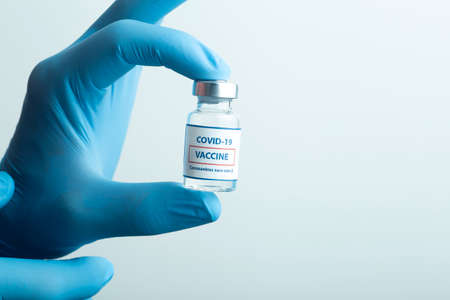 Vaccine against COVID-19. Glass medical vials with liquid. Ampoules with coronavirus vaccine on a medical glass tableの写真素材