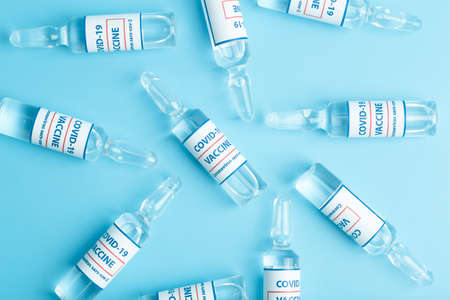 Vaccine against COVID-19. Glass medical vials with liquid. Ampoules with coronavirus vaccine on a medical glass tableの写真素材