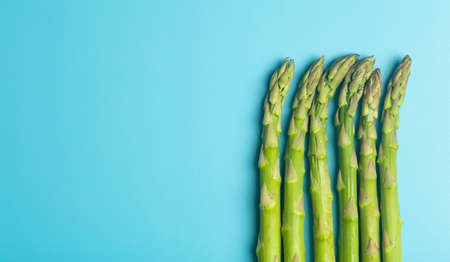 Asparagus on a white plate on a blue banner background. Fresh vegetable asparagus for a healthy diet and nutrition. Vegetables and healthy food conceptの写真素材