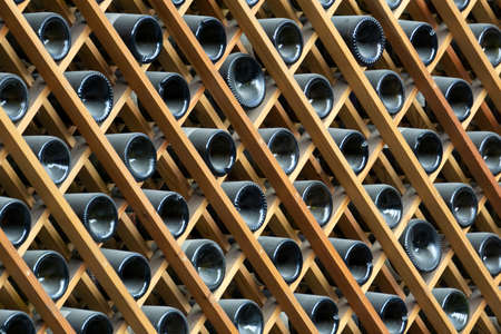Wine bottles background. Bottles of red and white wine in a wine cabinet of a liquor storeの写真素材
