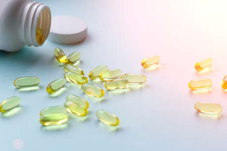 Omega fish oil background. Omega vitamins in yellow pills as a source of healthの写真素材