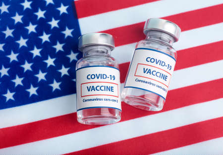 USA vaccine against coronavirus covid concept. Vaccine ampoules against the background of the national flag. Pharmacology and Medicine USA concept.の写真素材