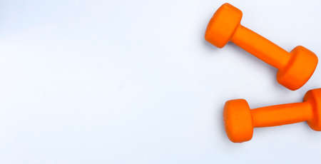 Sport concept with sport equipment composition. Sneakers, dumbbells, bottle of water on bright blue backgroundの写真素材