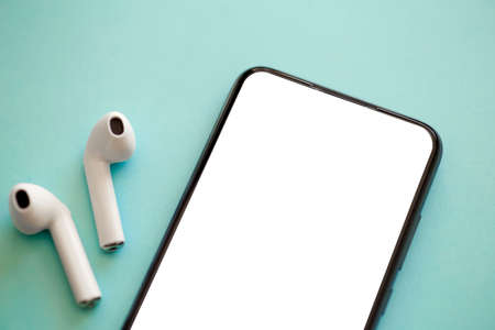 Smartphone blank screen on a colored background with headphones.の写真素材