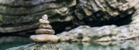 Harmony, balance and simplicity concept. A stone pyramid on the background of river water. Simple...