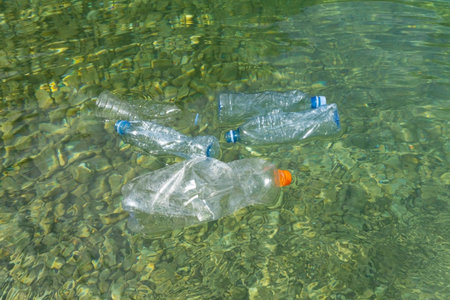 Plastic pollution in water. Dirty plastic bottles in a river. Pollution and recycle conceptの写真素材