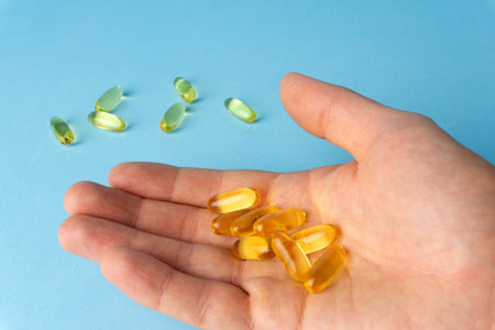 Fish oil fish fat capsules. Omega 3 vitamins in yellow gelatin capsules on a blue background