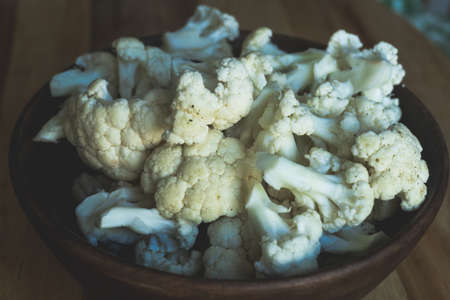 Cauliflower in a wooden bowl on the kitchen table prepared for cooking. Veg conceptの写真素材