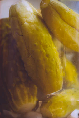 Pickled cucumbers in a marinade in a glass jar. Close upの写真素材