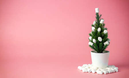 Christmas tree decorated with marshmallows instead of toys on a pink background. Minimal conceptの写真素材