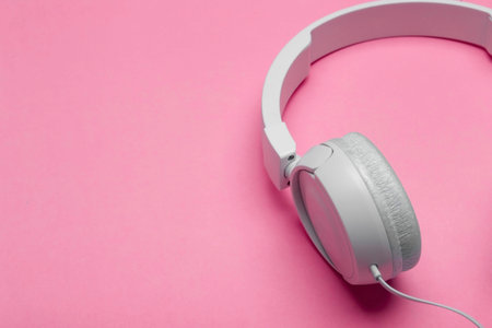 Musical headphones on a colored pink background. Aesthetics retro 80s and minimal concept.
