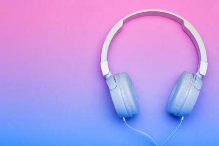 Musical headphones on a colored blue and pink background. Aesthetics retro 80s and minimal concept.の写真素材