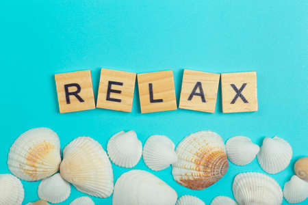 Relax concept. The inscription Relax on a light blue minimal background with seashells.の写真素材