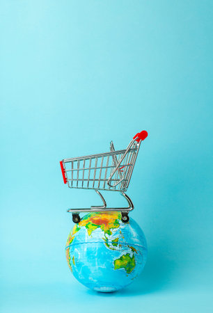 World sale and Internet sales concept. Supermarket cart with earth globe on blue background. World...
