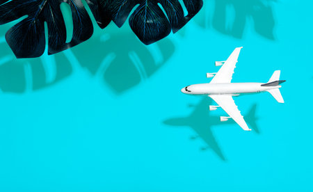 Travel minimal background. Model airplane in flight on an empty colored background with shadows of...