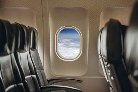 Airplane window in clear sunny weather. Interior of a passenger plane with an open window in flight. high quality photoの写真素材