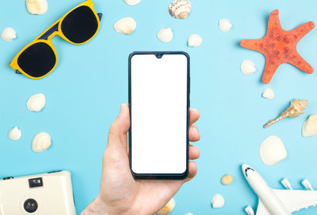 travel app concept. Empty screen smartphone on a colored background with travel items, sunglasses,...