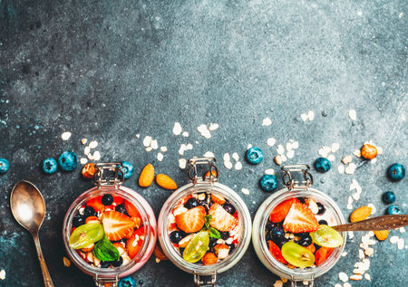 Yogurt with granola, fresh berries and nuts in a jar on a dark background. Healthy breakfast and dessert concept. Beautiful bright food photo. high quality photoの写真素材