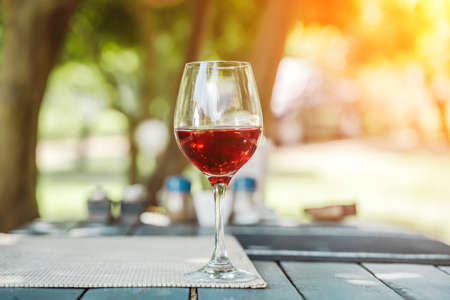A glass of red wine on the table of a street cafe a sunny summer day. Summer, lifestyle, relaxation, and enjoyment concept.の写真素材