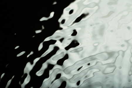 Water tranquil ripple black background. Water texture, circles and bubbles on a liquid black gray...