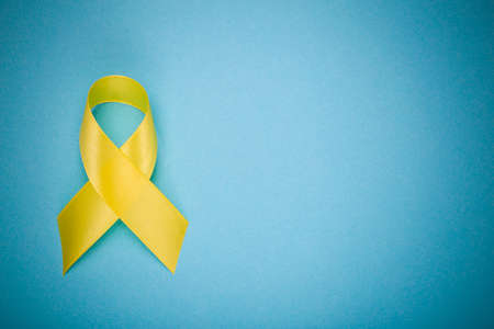 Yellow ribbon, Childhood Cancer Awareness Month. Cancer or suicide prevention ribbon. Children healthcare background. Copy spaceの写真素材