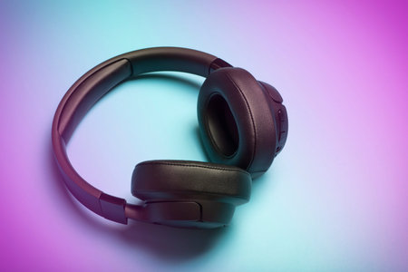 Wireless sound Audio headphones on a colored neon background. Music app, listening to podcasts,...