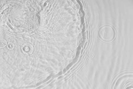 Water tranquil ripple background. Water texture, circles and bubbles on a liquid white surface. Cosmetic products and flat design concept. high quality photoの写真素材