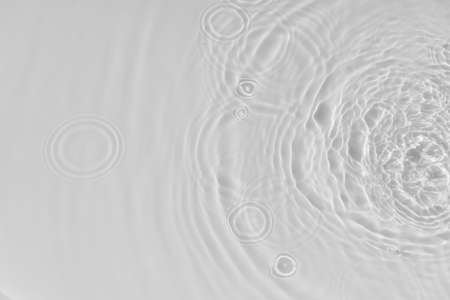 Water tranquil ripple background. Water texture, circles and bubbles on a liquid white surface. Cosmetic products and flat design concept. high quality photoの写真素材