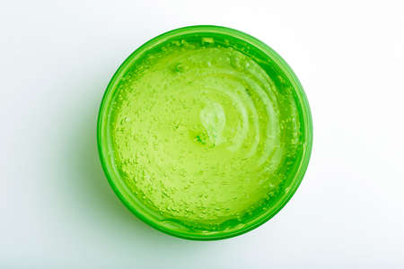 Cosmetic gel in a jar on a white background. Green transparent gel with texture and bubbles isolateの写真素材