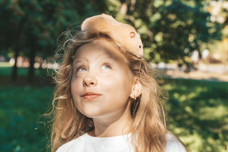 Girl with a hamster in nature. Cheerful happy child girl with pet hamster plays in the backyard of the house in summer. Love, care, tenderness concept.の写真素材