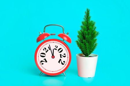 New Year 2022 background concept. 2021 changes to 2022 on an alarm clock on a blue background with...