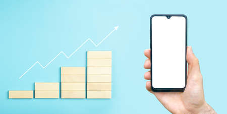 Business growth, development plan concept and business analytics background. Hand with blank smartphone for stock exchange applicationの写真素材