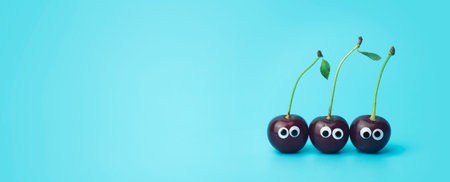 Cherry eyes on a blue background. Funny vegetables and fruits for children. Baby food concept, food face.の写真素材