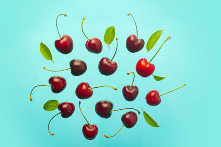 Cherry minimal background. Red summer cherry berries on a blue empty blue background. Summer fruits...