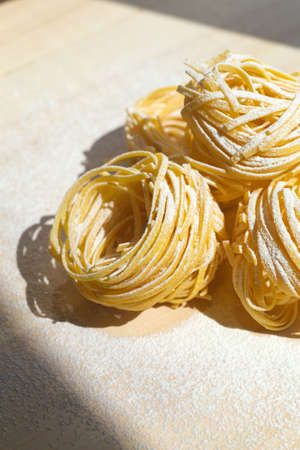 Fresh pasta food. Homemade Italian pasta cooked on a wooden background in a rustic style decorated with egg and flour.の写真素材