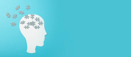 Dementia, alzheimer, memory and mental brain health concept background. Paper head with puzzle pieces on a blue backgroundの写真素材