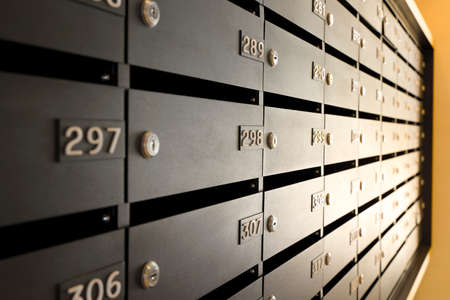 Mailboxes for letters and correspondence. Modern black mailboxes with numbers in the lobby of a residential or office buildingの写真素材