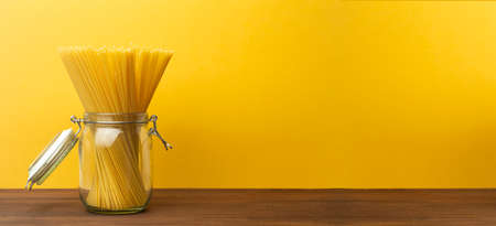 Italian pasta on a yellow kitchen background. Fresh spaghetti pasta for home cooking. Pasta backgroundの写真素材