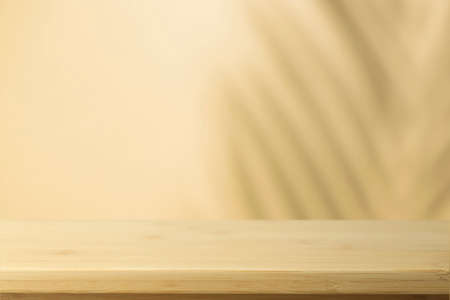 Flat lay background. Minimal background with shadows of palms and empty wooden table.の写真素材