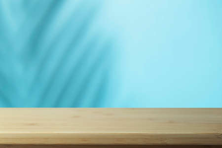 Flat lay background. Minimal background with shadows of palms and empty wooden table.の写真素材