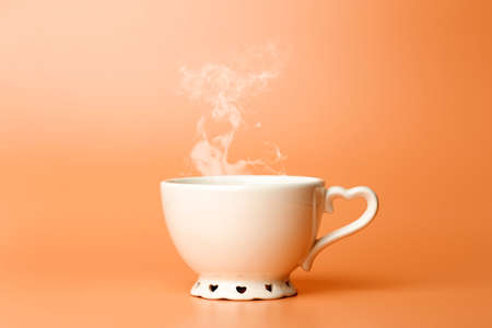 Cup minimal concept. Cup with hot coffee or tea on a blank colored background.の写真素材