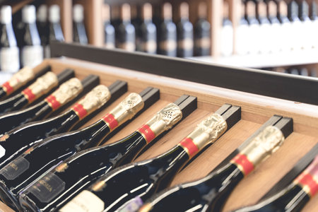 New York, USA - 1 January 2022: Wine bottles on the counter of a liquor store. Wine background.のeditorial素材