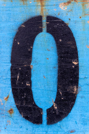 Numbers 0 black paint on an old blue iron surface with rust texture and traces of dirt.