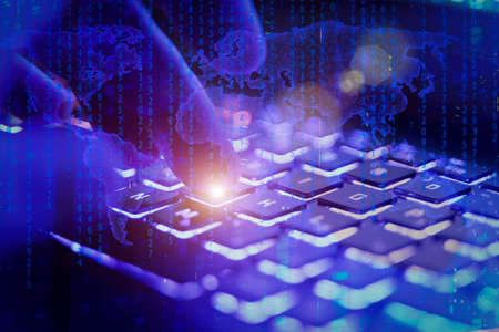 Big data analytics and global financial market background concept. Hand on a colorful neon keyboard on the background of digital holograms of global financial charts, data, calculations.の写真素材