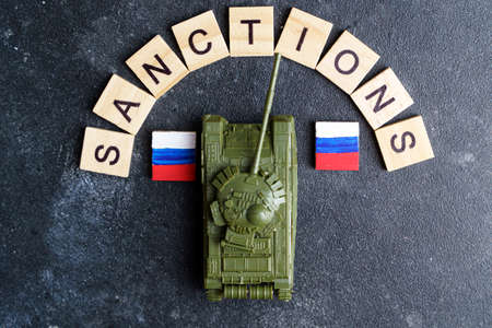 Sanctions against Russia concept. Toy tank and the inscription Sanctions on a dark background. War conflict in Ukraine, default, economic and monetary crisis in Russia. high quality photoの写真素材