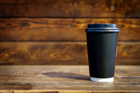 Coffee paper cup on wooden table background. Drink coffee take away mockup.の写真素材