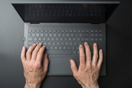 Laptop computer keyboard with user or gamer hands on black stylish background. Technology, business,...