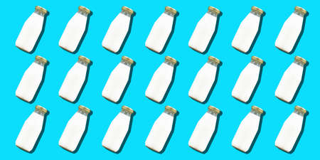 Milk bottle minimal background. Many glass bottles of white cows milk or yogurt in a pattern.の写真素材