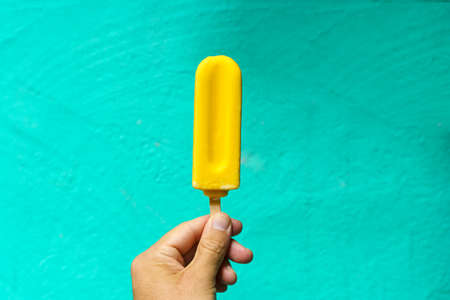 Ice cream cone in hand on minimal color background isolated. Summer, food, sweets, ice cream concept.の写真素材